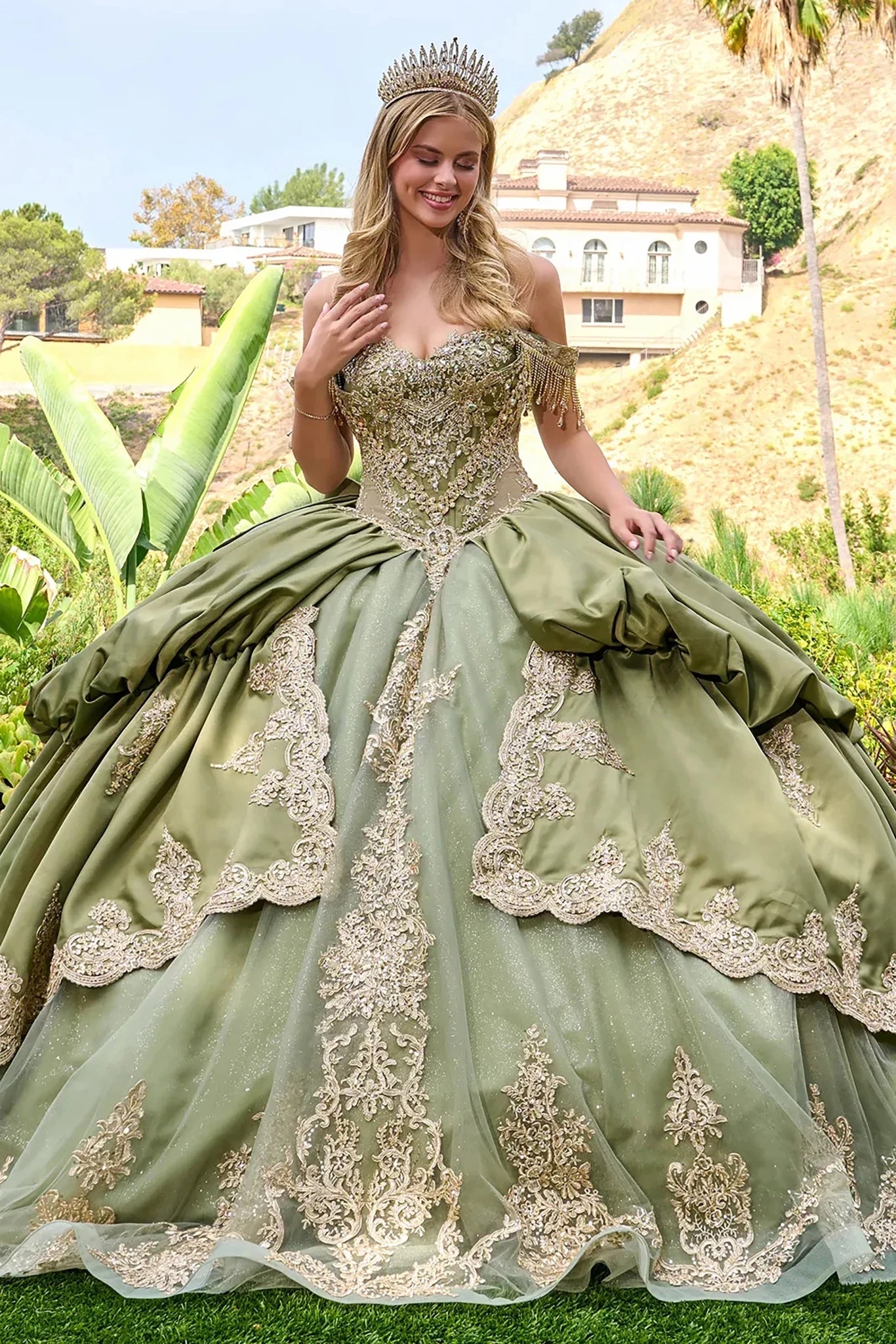 Front view of a woman wearing sage quinceañera dress with gold scalloped embroidery jewel straps bubble hem overskirt ball gown tiara