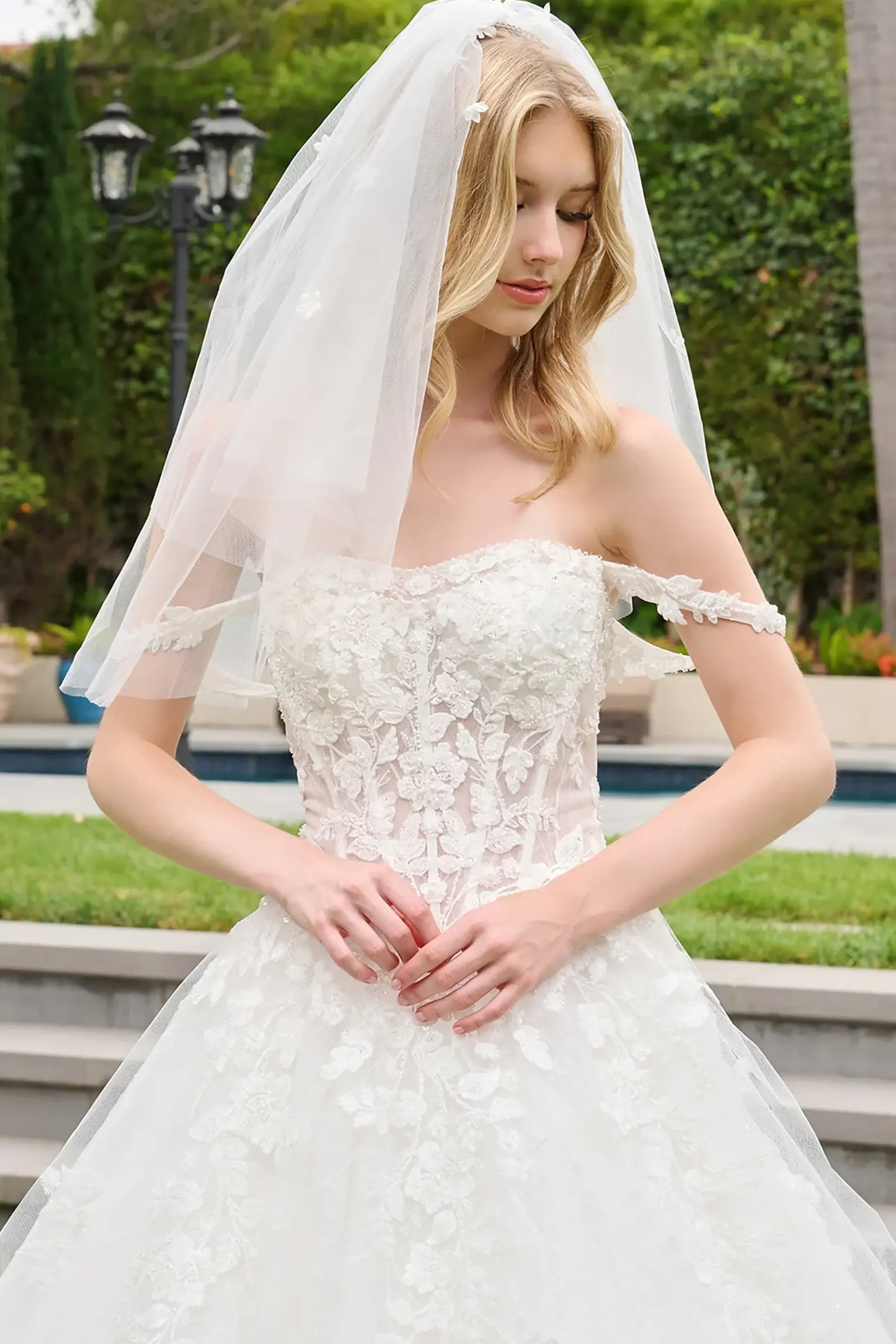 Off-white quinceañera ball gown completed with short veil