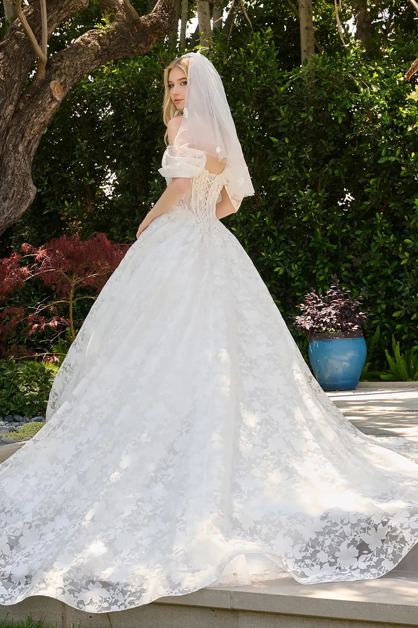 Off-white wedding dress layered over glitter mesh underlayer that adds subtle sparkle and depth lace back up