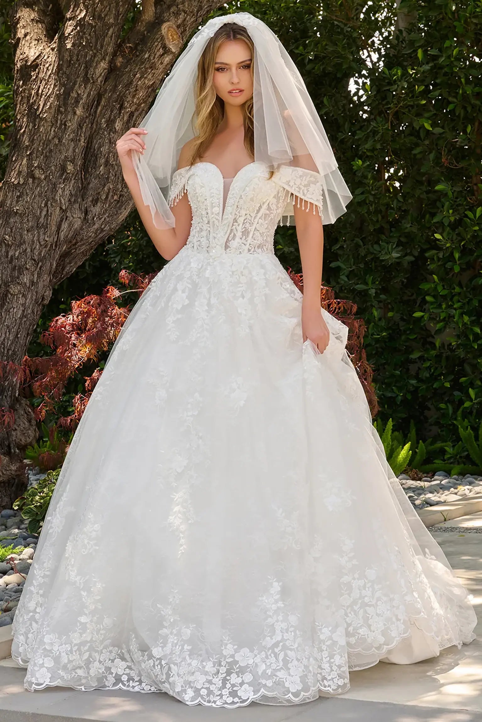 Off-white wedding dress with V-neckline flowing into fold-over off-shoulder straps