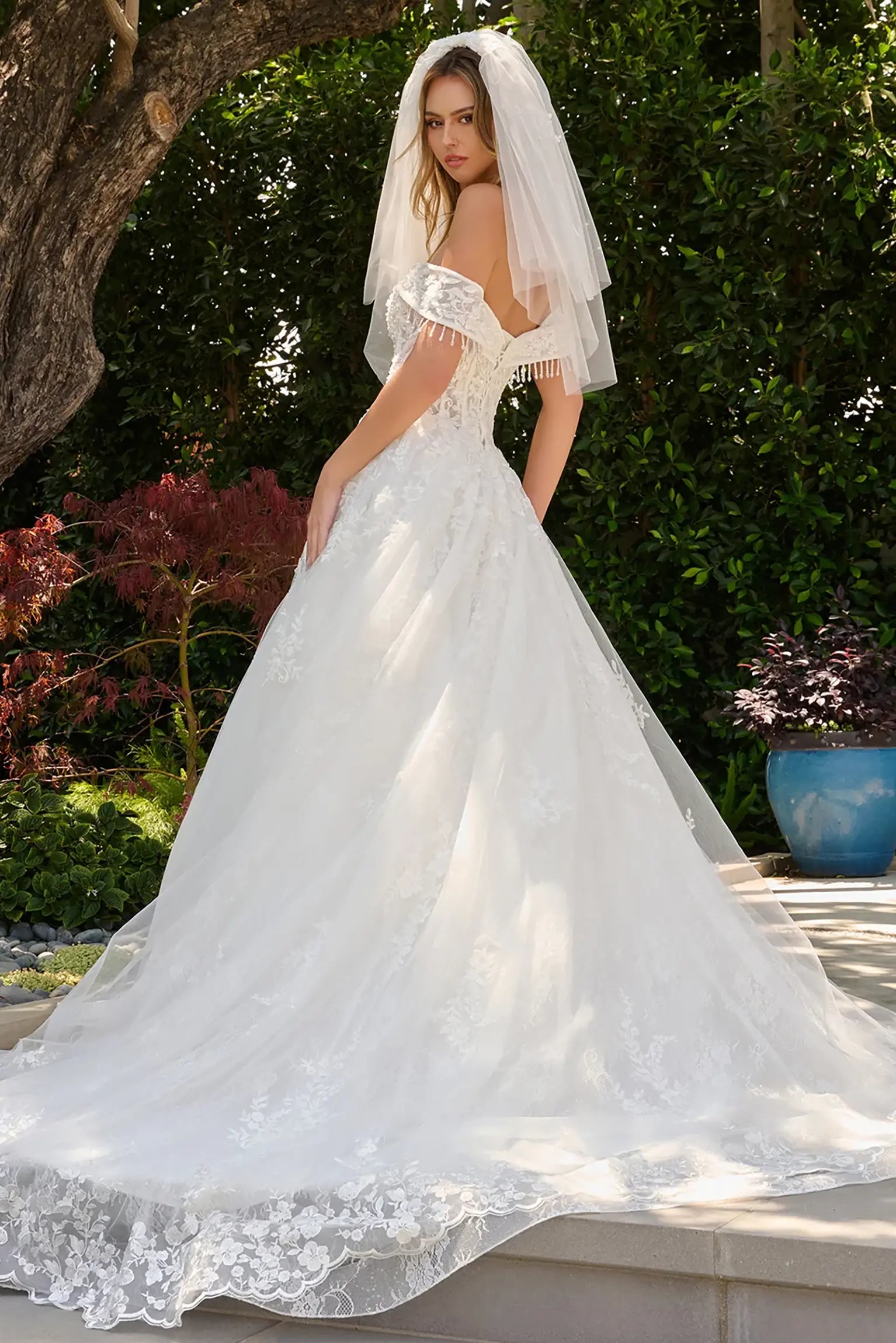 Off-white wedding dress featuring dangling bead details accenting the strap edges