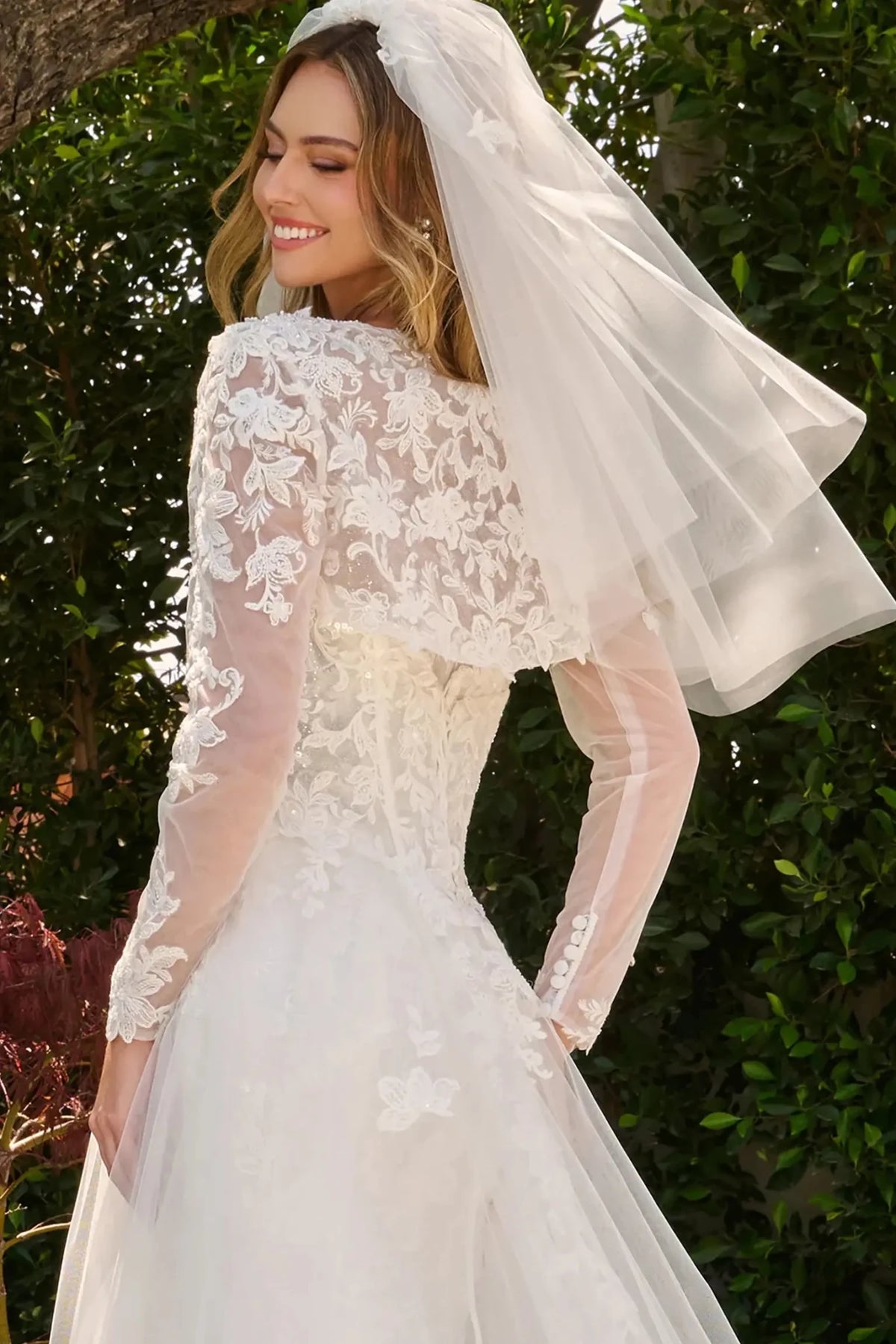Off-white wedding dress styled with bolero shrug finished with dangling bead accents and floral embroidery