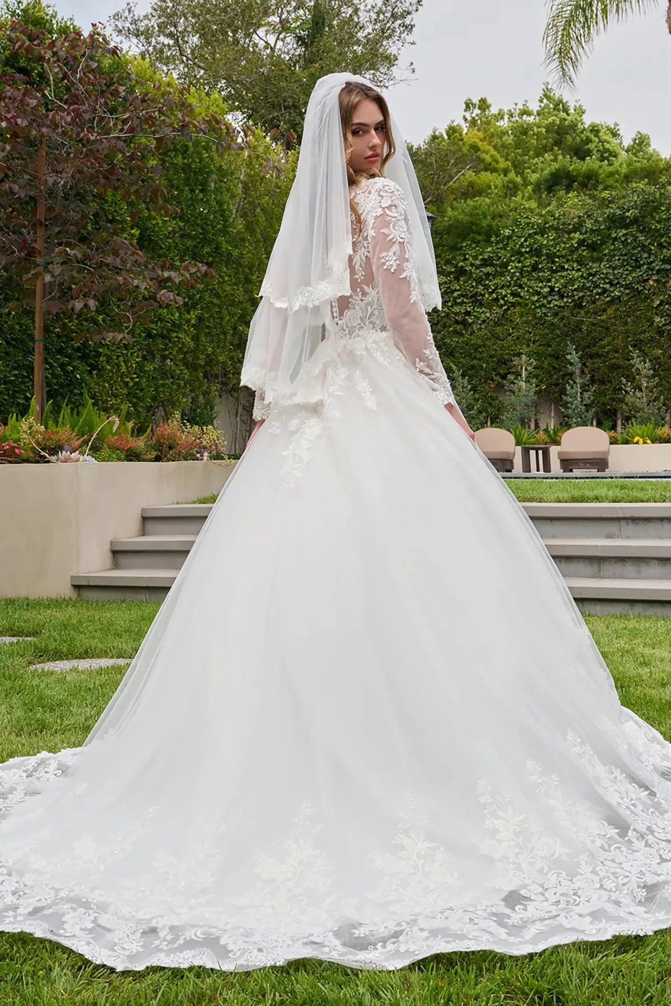 Off-white wedding dress with embroidered hem and train over glitter mesh