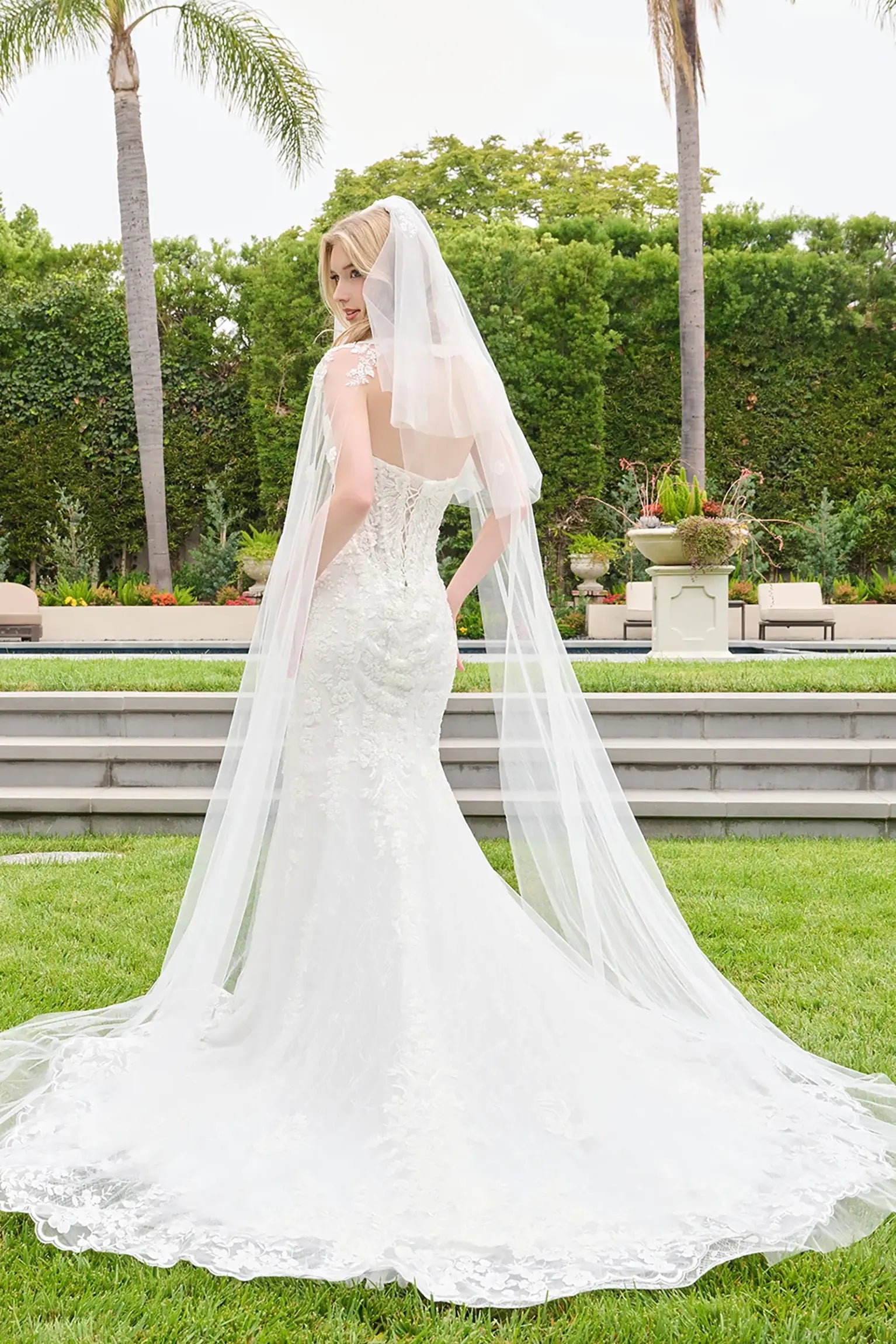 Off-white wedding dress with scalloped embroidery tracing hem and flowing into train and lace back up