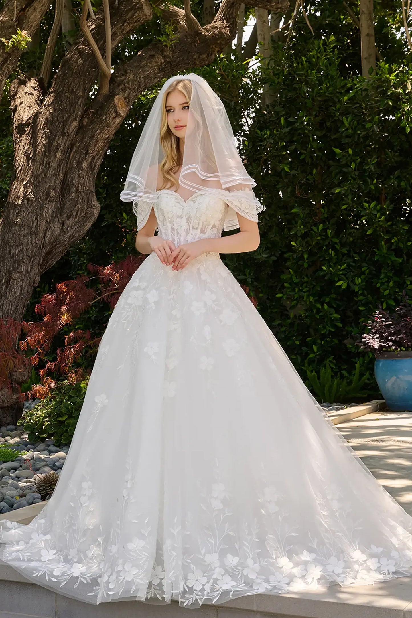 Off-white wedding dress styled with dimensional embellishments for refined bridal silhouette