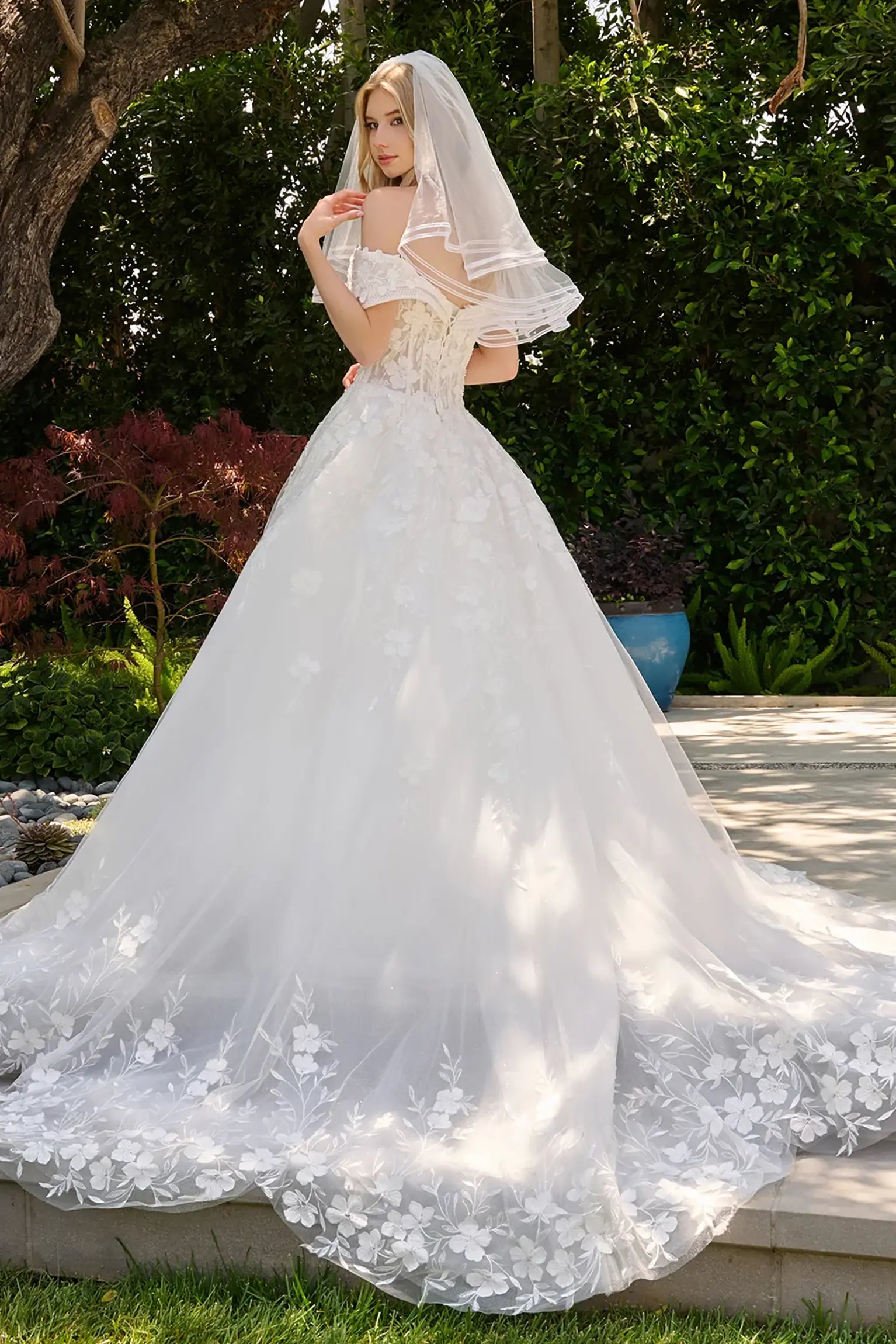 Off-white wedding dress showcasing scalloped hem embroidery extending into flowing train