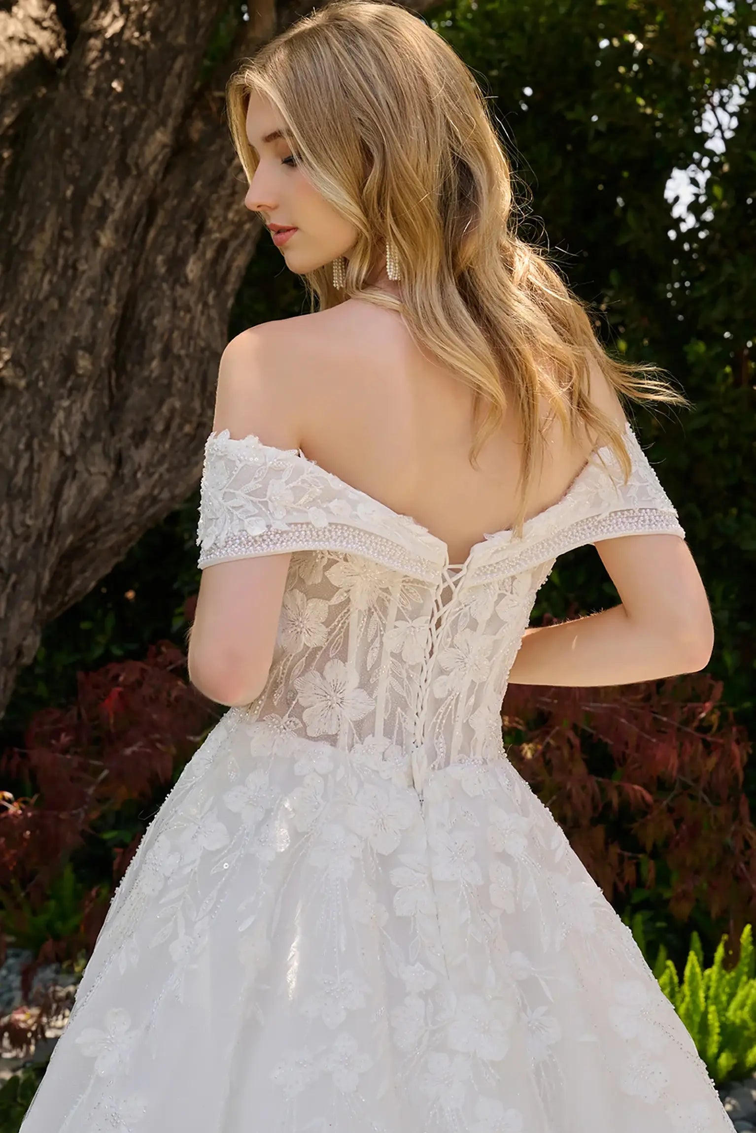 Off-white wedding dress styled with layered beaded of the shoulder straps and lace back up corset