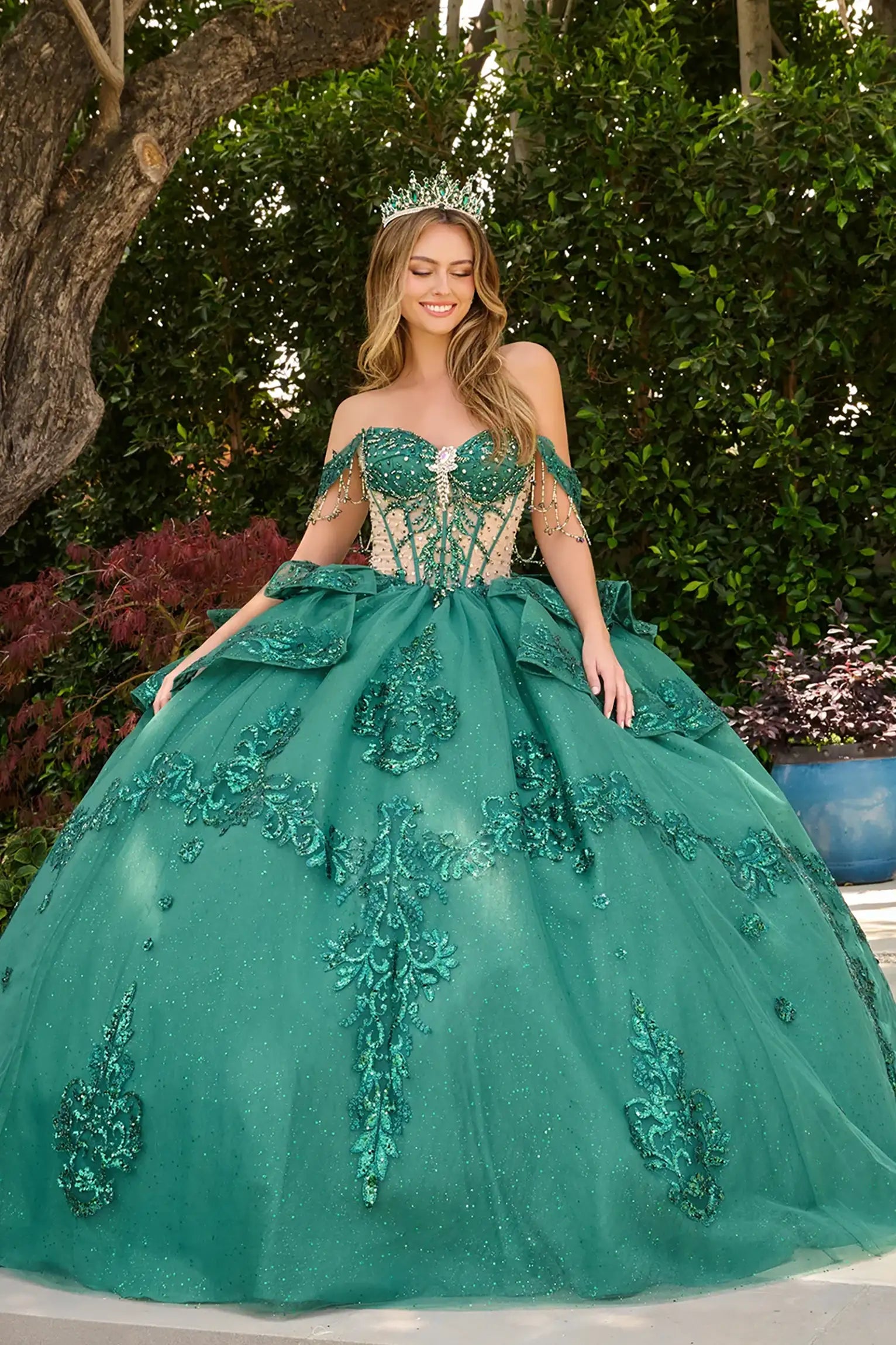 Green quinceañera ball gown with bejeweled grommets, glitter underlayer and dramatic train finish