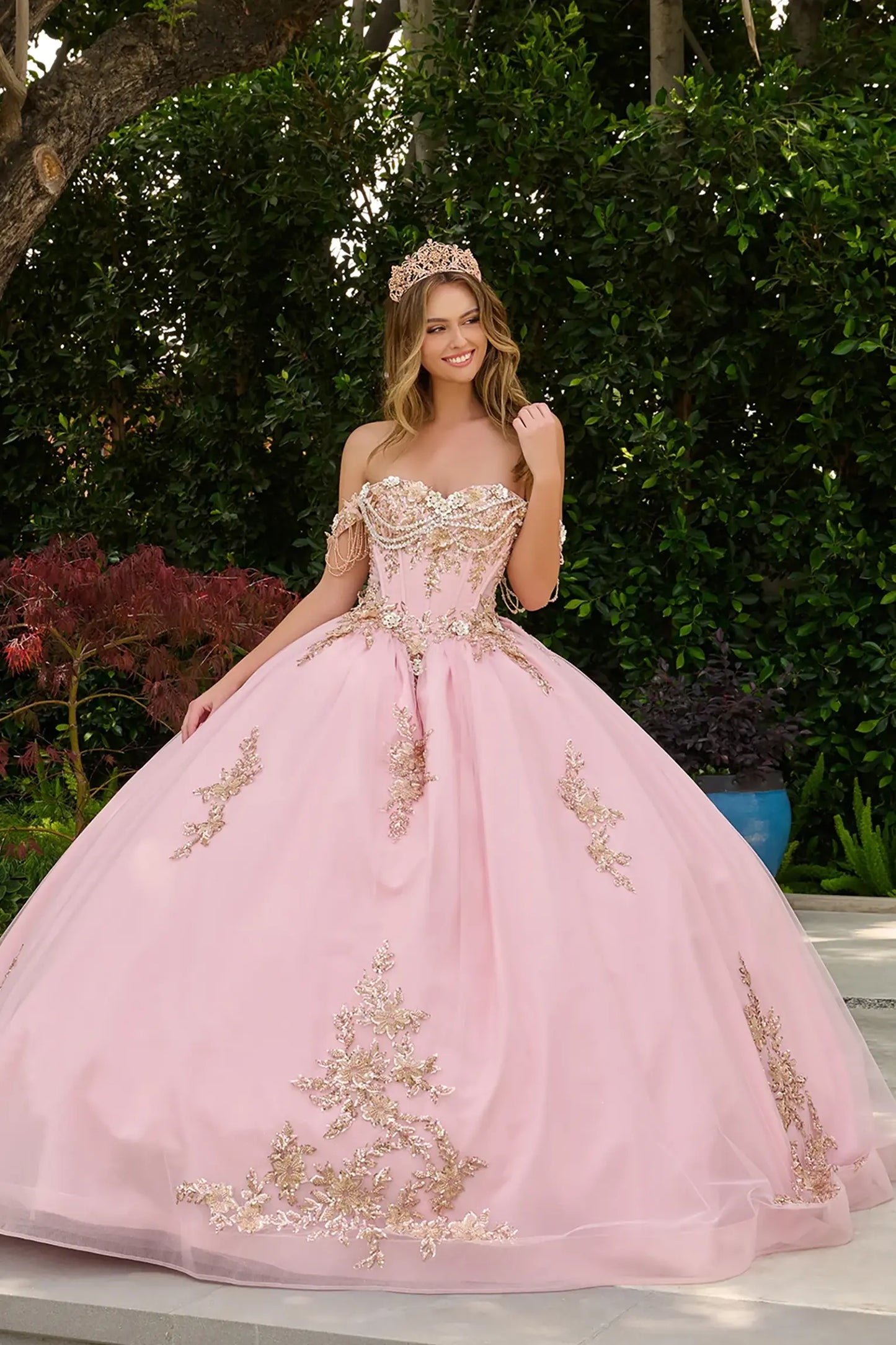Blush quinceañera ball gown highlighting dimensional 3D metal flowers and radiant embellished silhouette