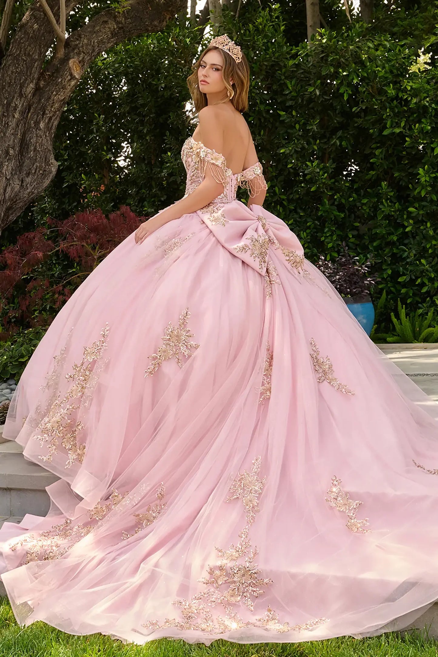 Blush quinceañera ball gown completed with detachable bow at back for refined and elegant finish