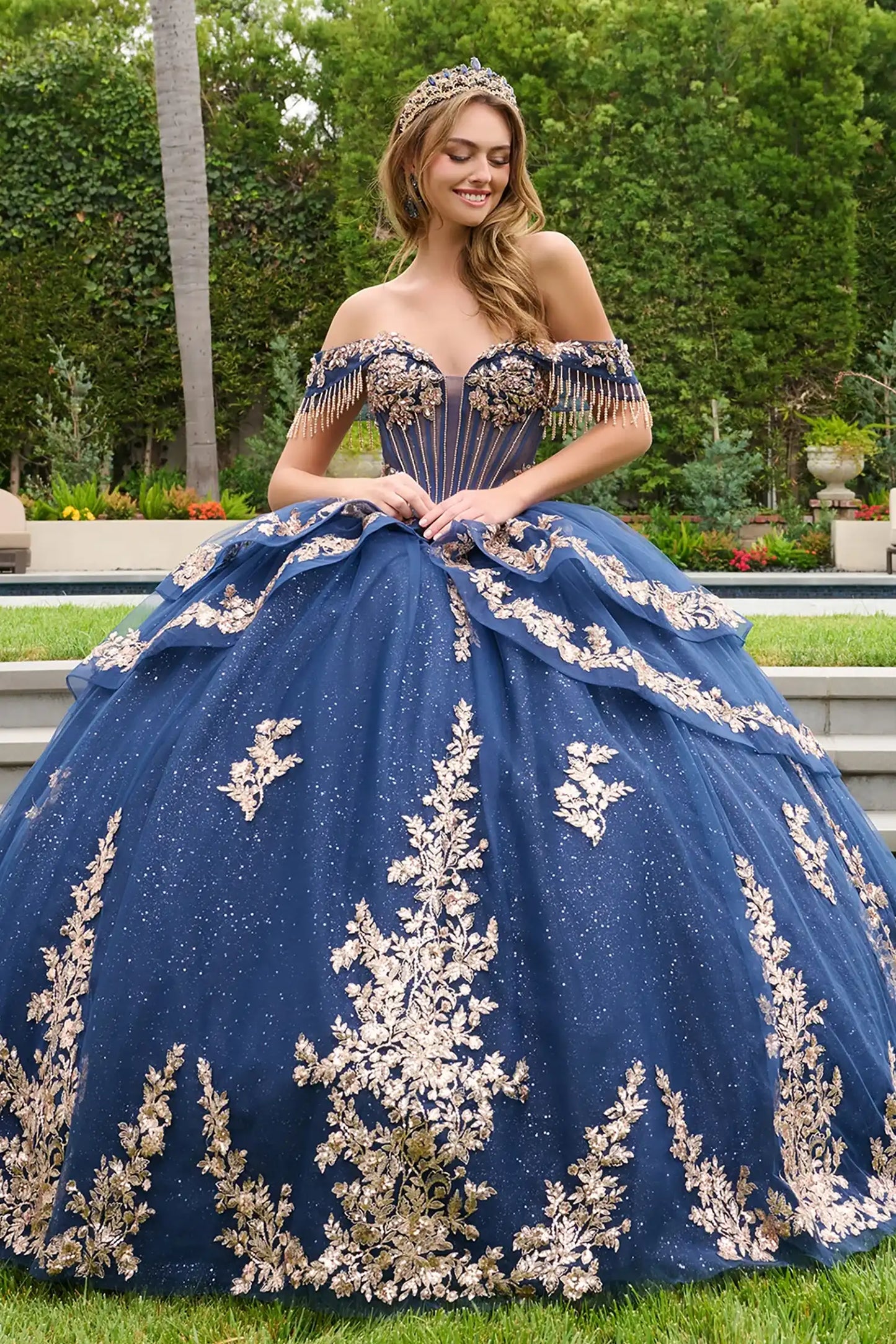 Navy quinceañera ball gown with double-layered off-shoulder straps and delicate dangling bead accents