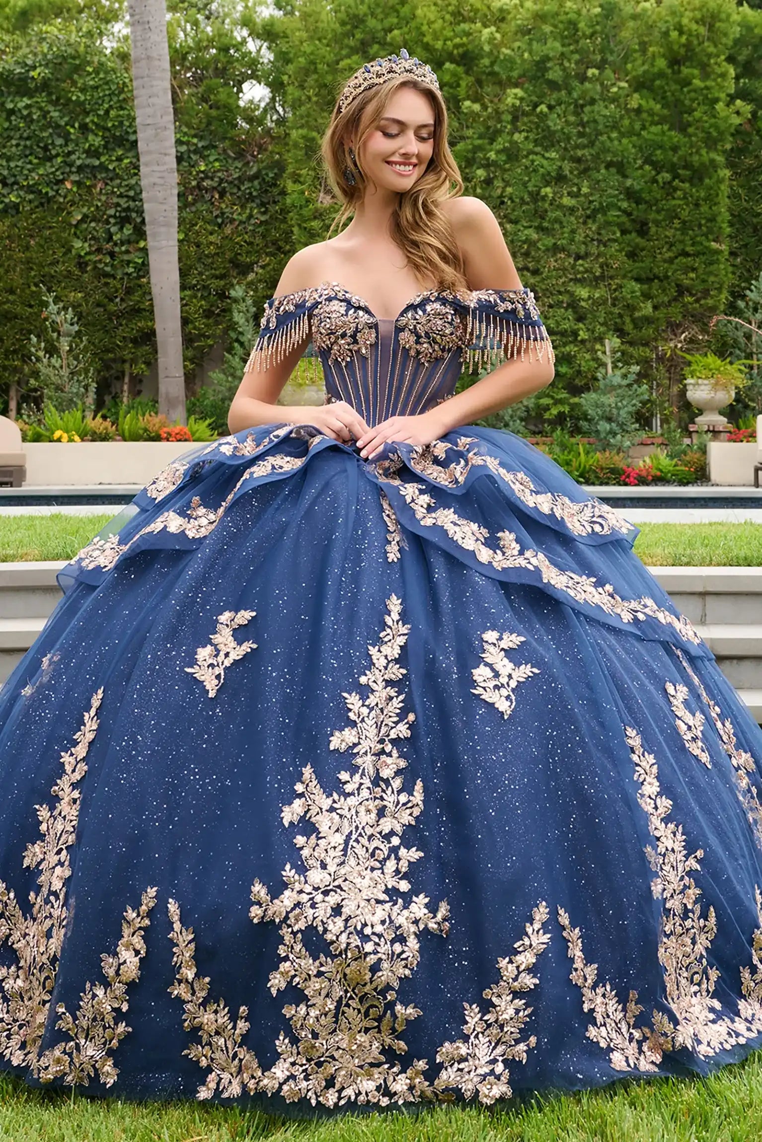 Navy quinceañera ball gown with double-layered off-shoulder straps and delicate dangling bead accents