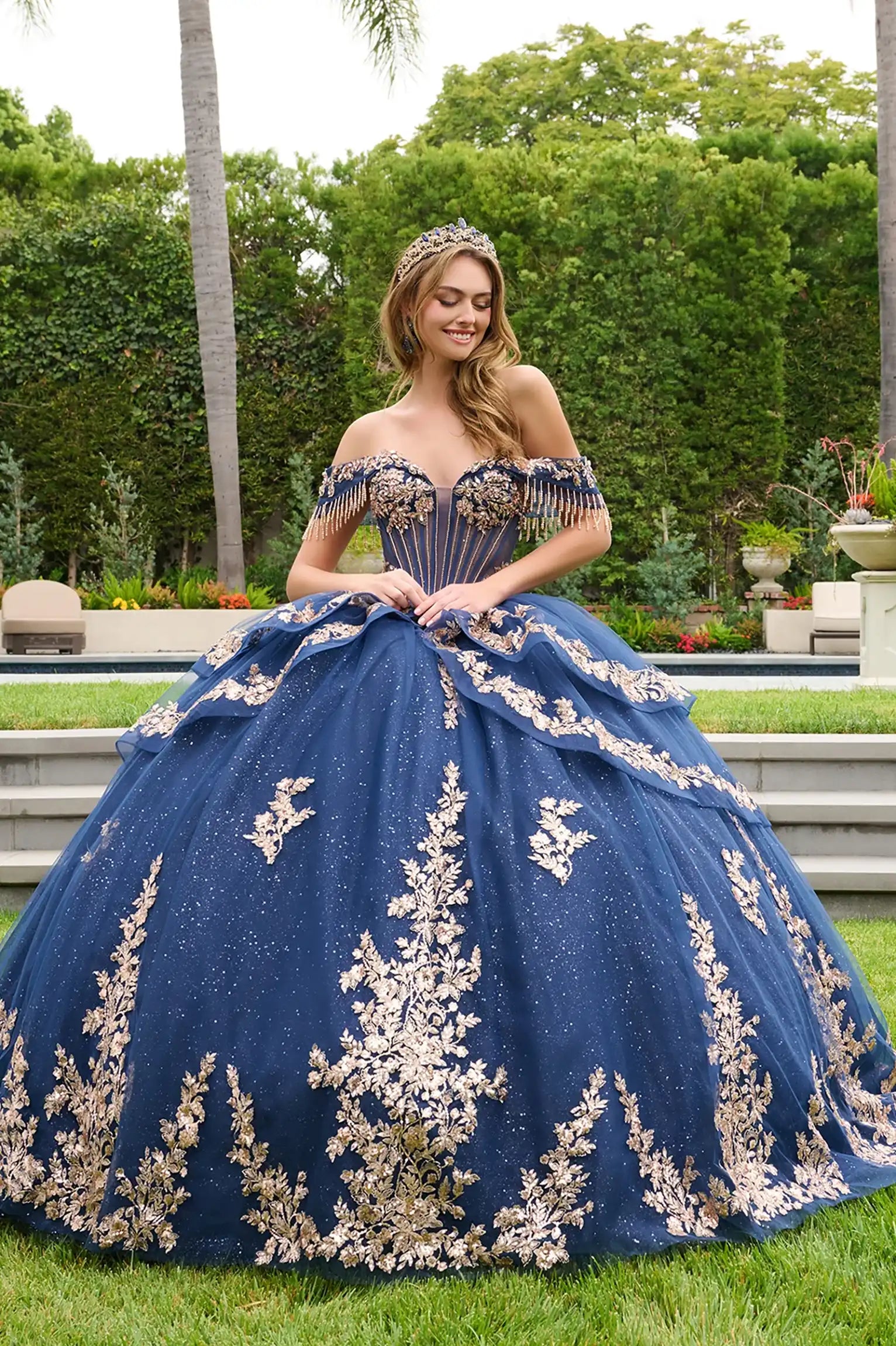 Navy quinceañera ball gown highlighting ornate corset embellishments and radiant layered silhouette