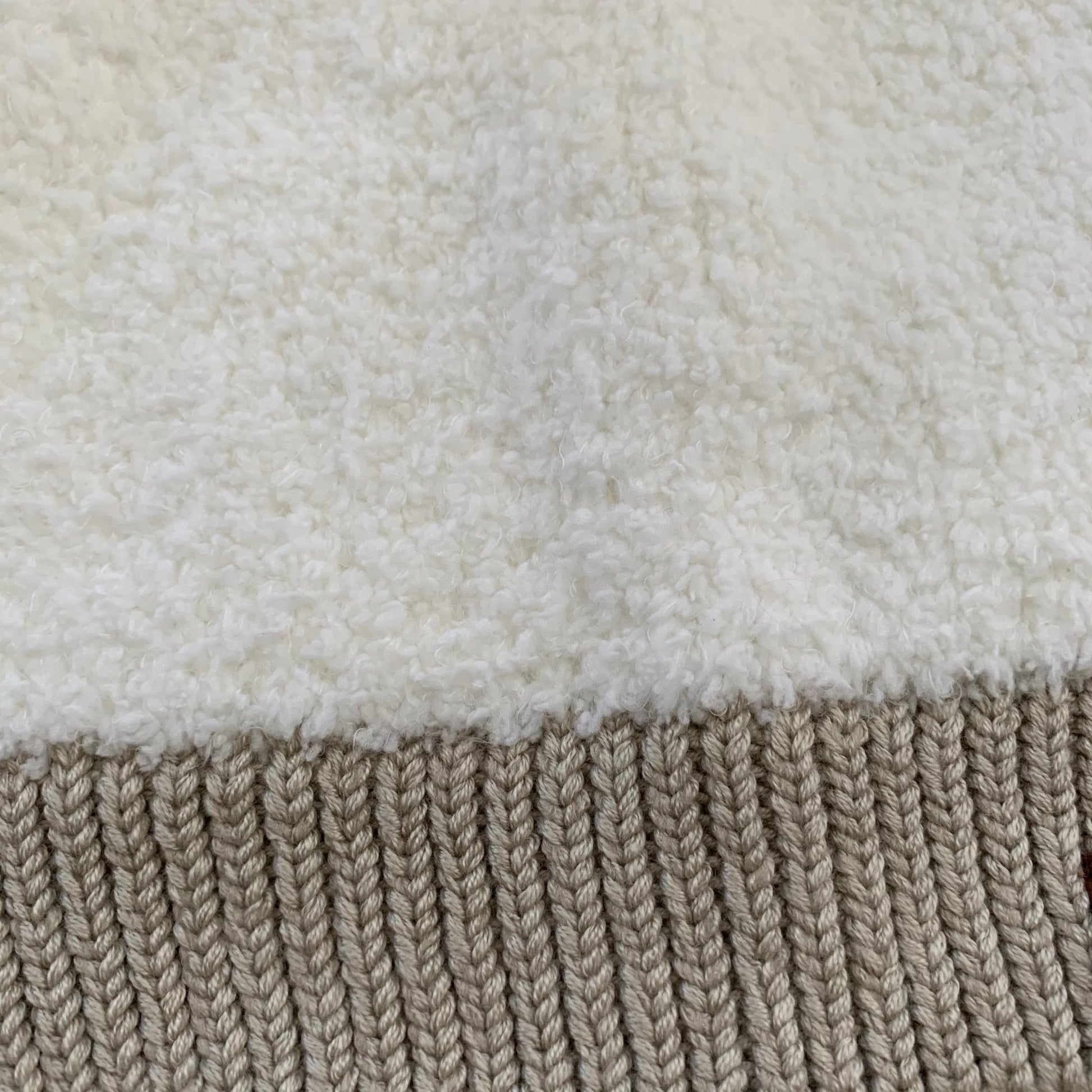 Multi color sherpa pom-pom women's winter beanie, close-up view.