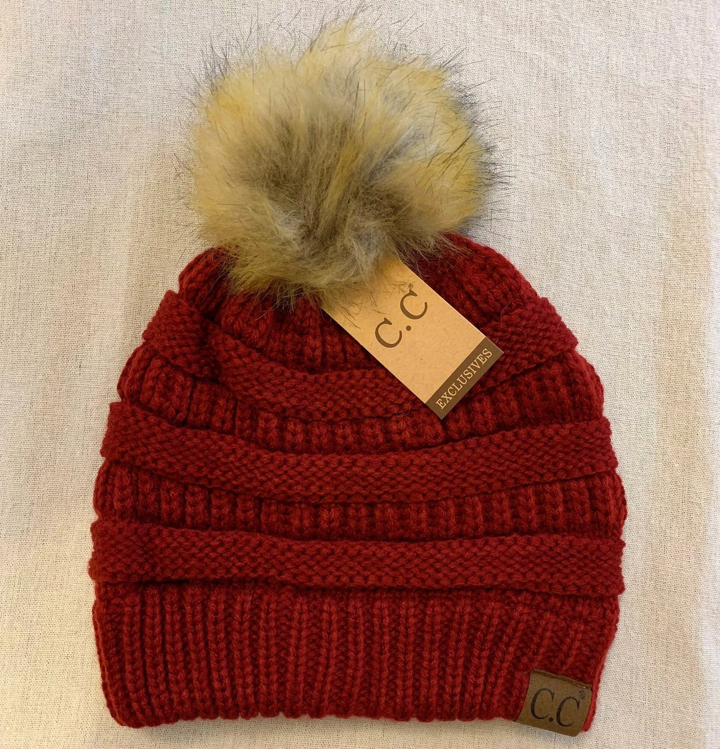 Burgundy pom-pom women's winter beanie.
