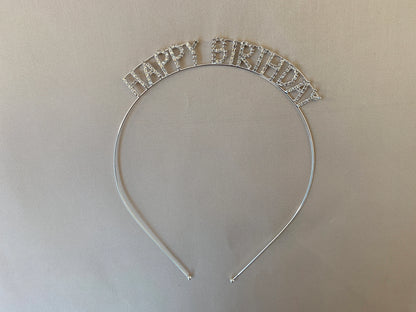 Silver 'Happy Birthday' headband on a beige background