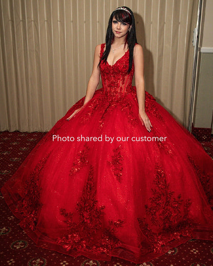 Woman wearing a red ball gown with floral details on a carpeted floor.