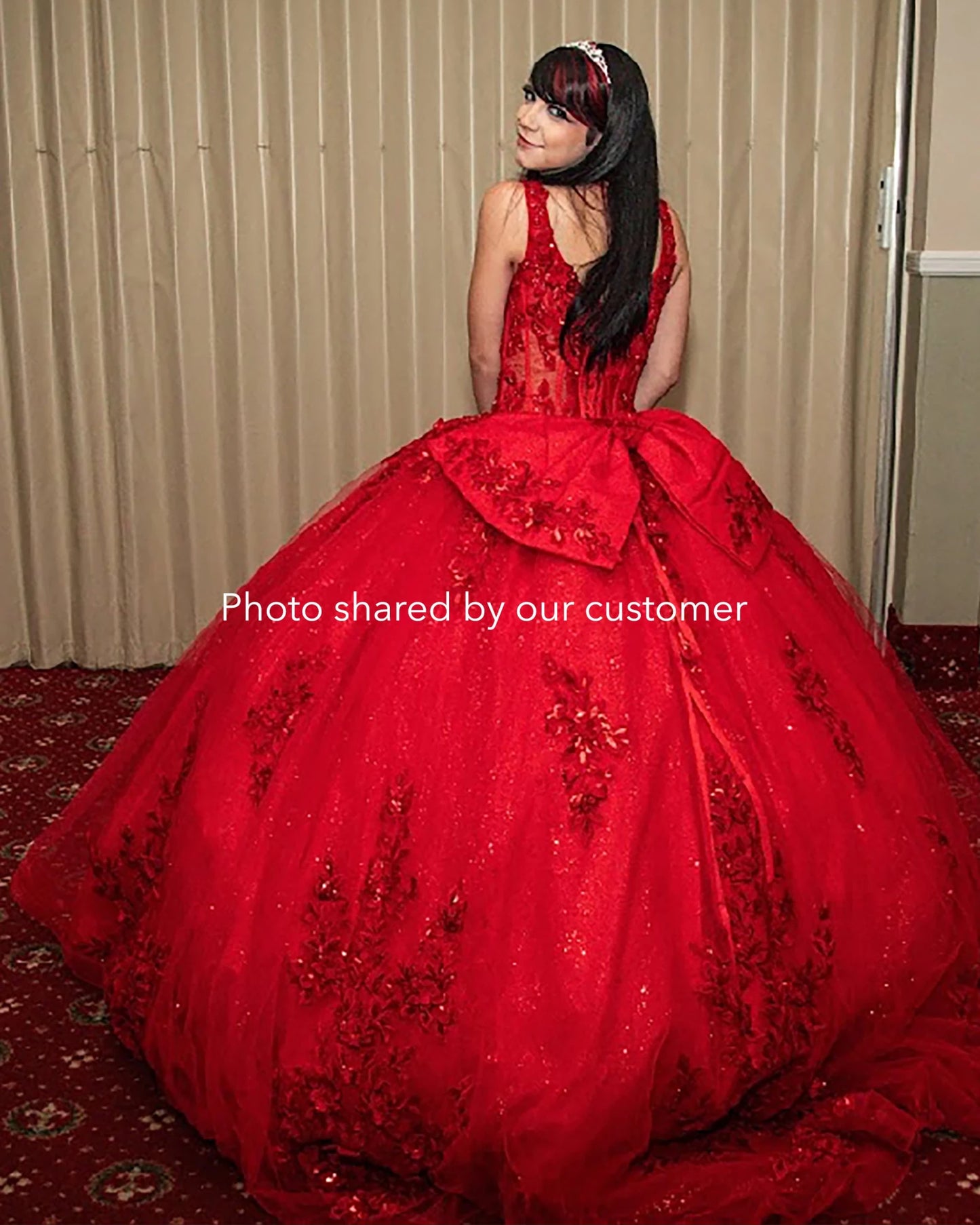 Red ball gown with floral details on a patterned carpet