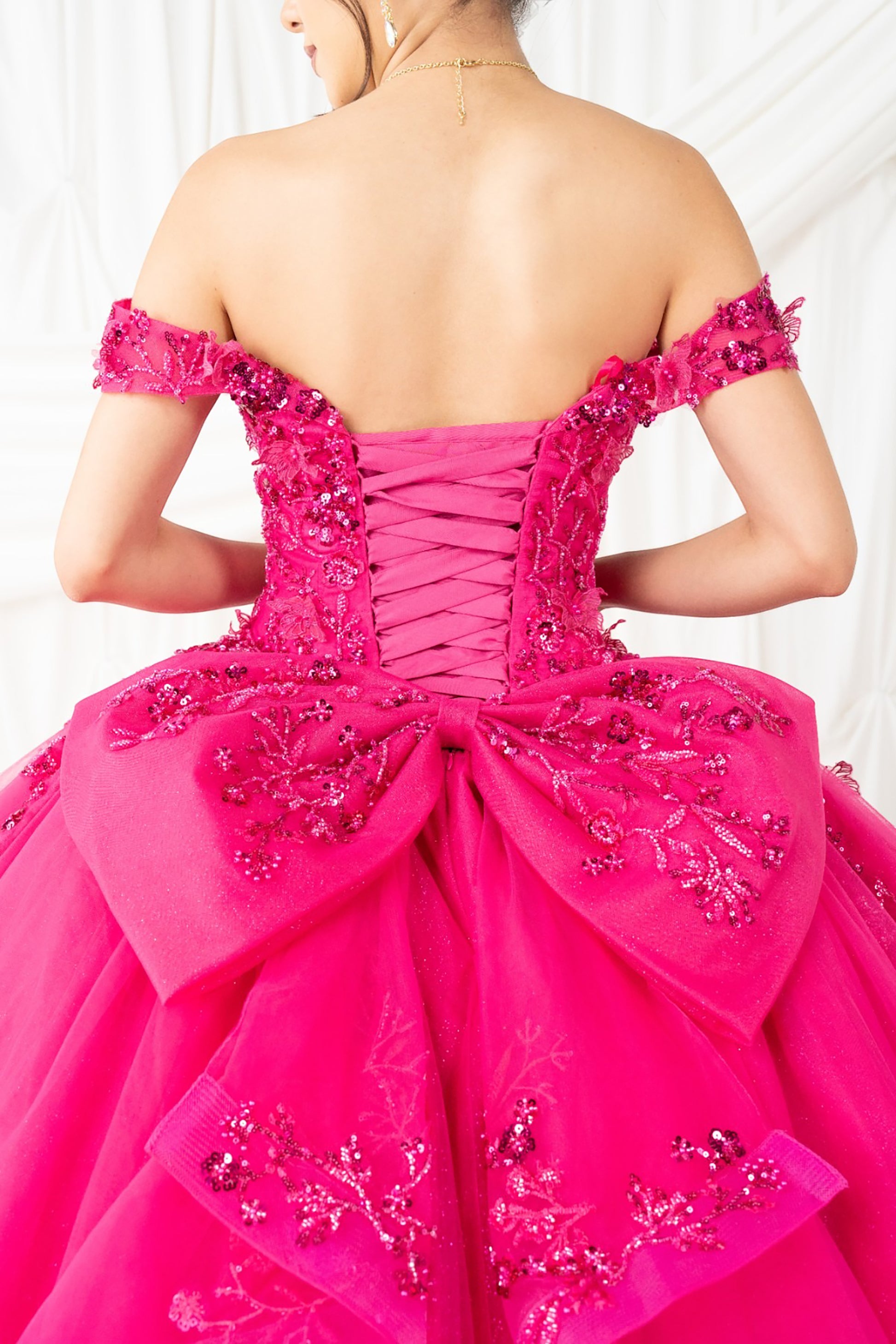  fuchsia off-shoulder gown with intricate detailing on a white background