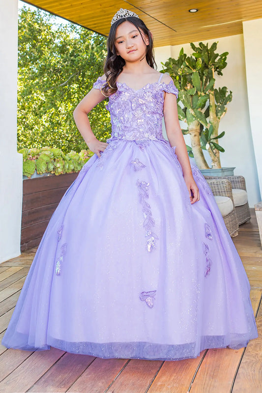 Young girl in a lilac ball gown dress with floral and butterfly details standing outdoors.