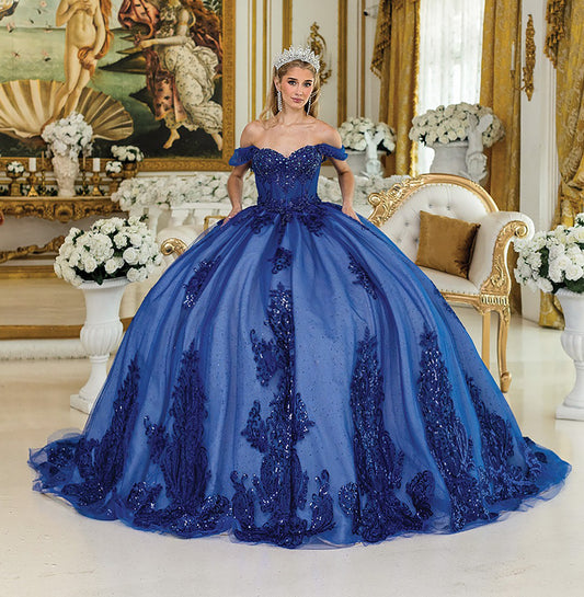 Woman in a blue ball gown standing in an ornate room with decorative elements.