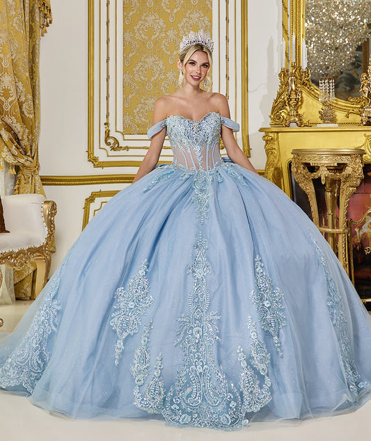 Woman in a light blue gown with intricate detailing in an ornate room.