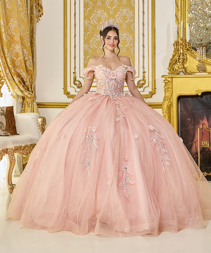Woman in a pink off-shoulder gown with floral embellishments in an ornate room.