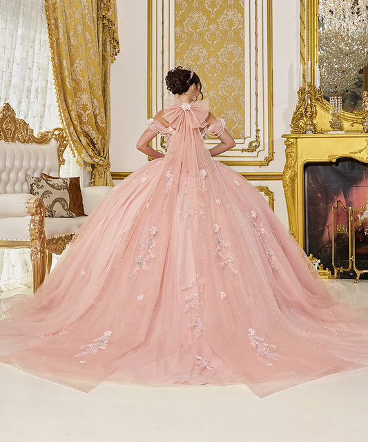 Woman in a pink gown standing in an opulent room with gold decor.