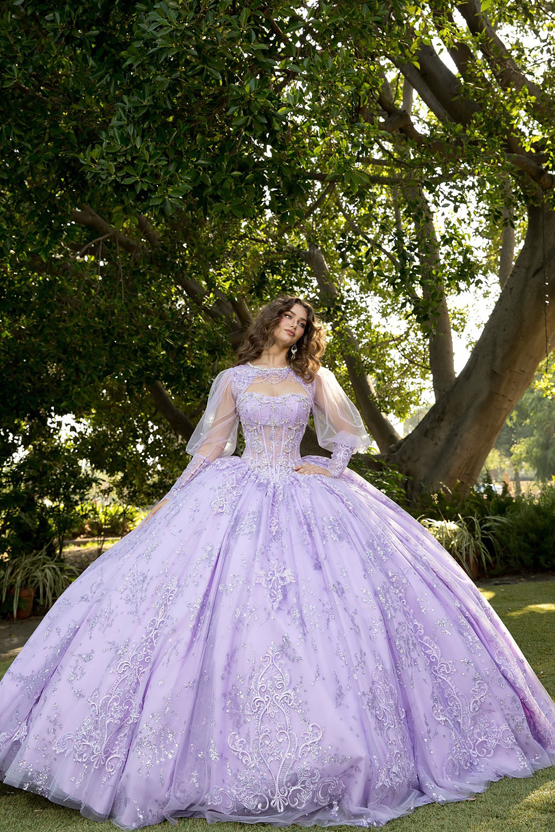 Woman in a lavender wedding dress standing in a park with trees and greenery.