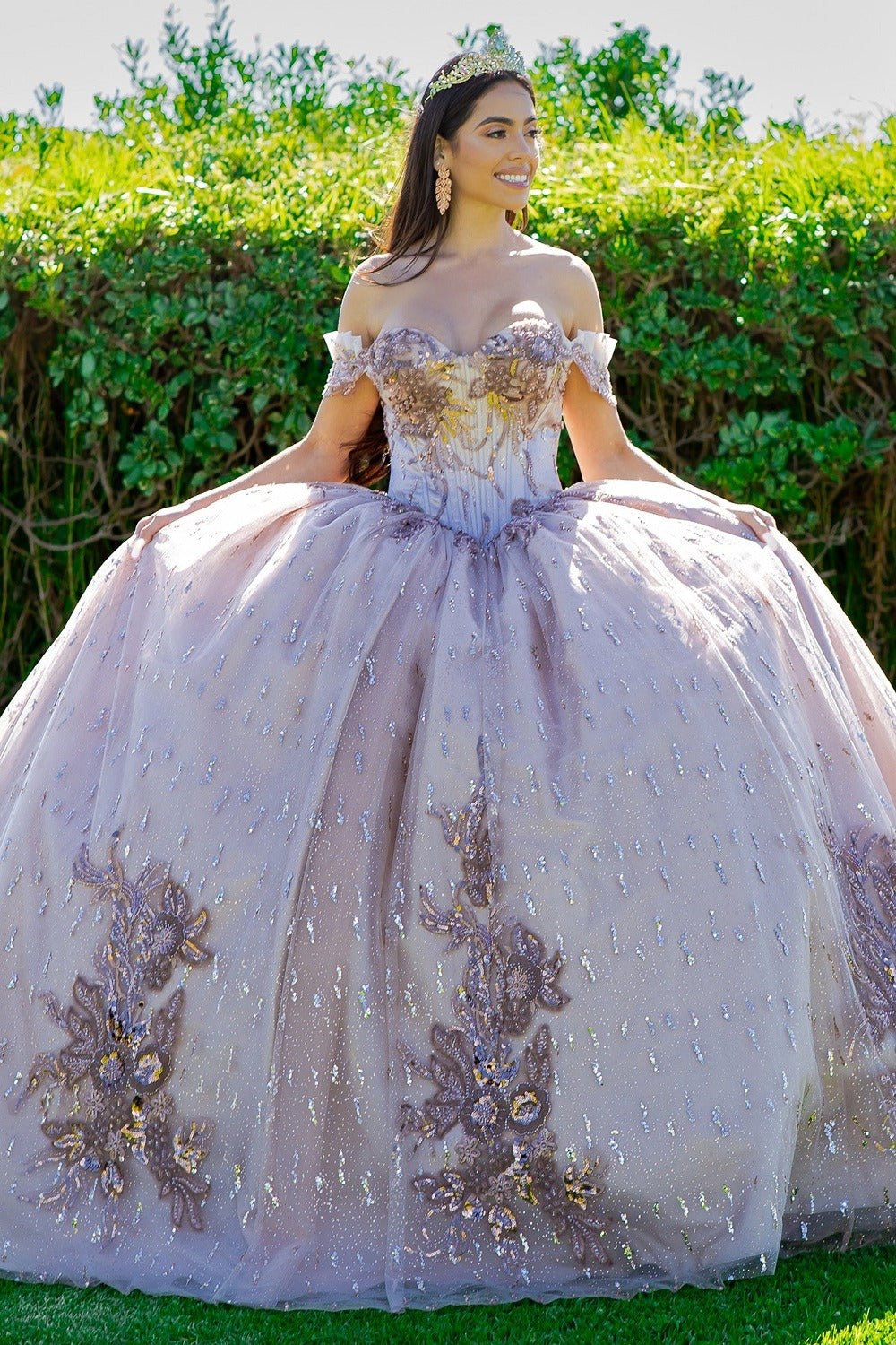 Woman in a lavishly decorated  mauve quinceanera dress with floral patterns outdoors.