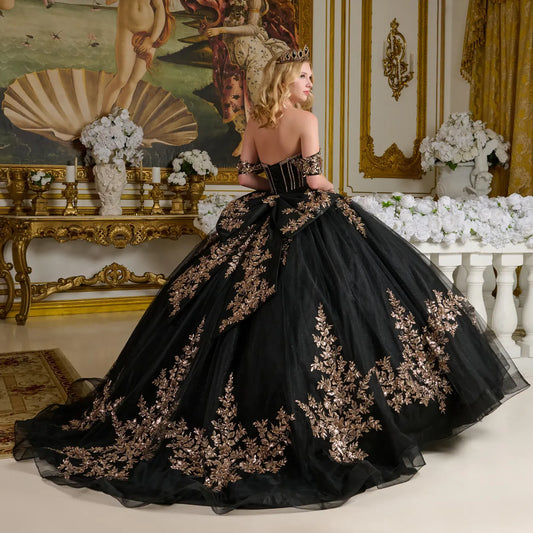 Woman in a black gown with gold embroidery in an ornate room.