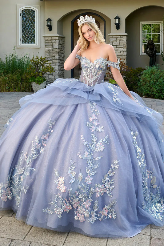 Woman in a dusty blue floral quince dress standing in front of a house.