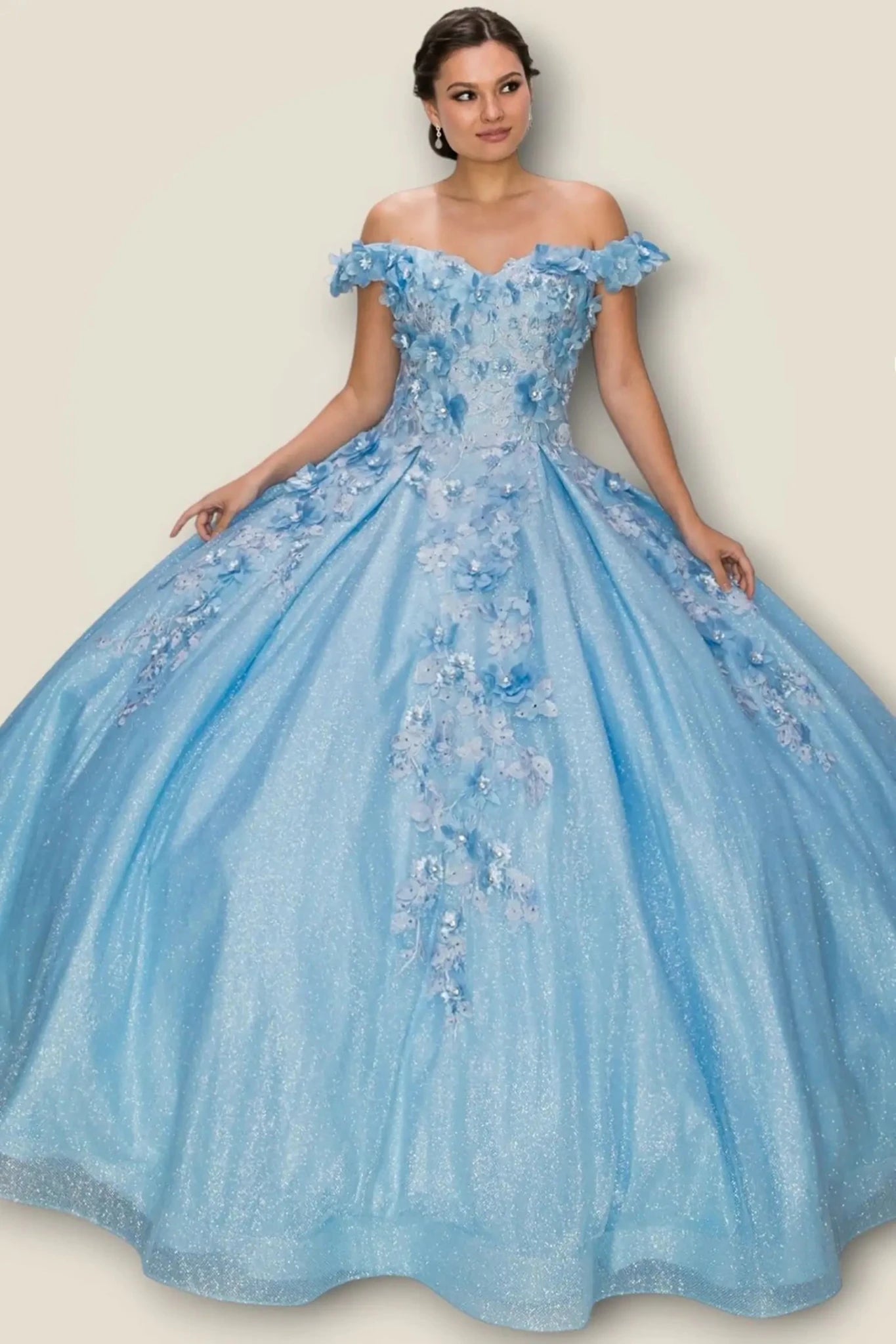 Woman wearing a blue off-shoulder gown with floral embroidery on a beige background