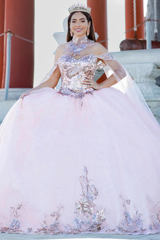 Woman in a pink and pink-silver sequin quinceañera dress with a tiara, standing outdoors.