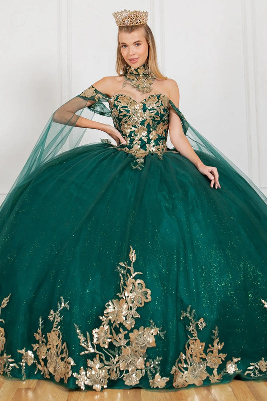 Woman wearing a green and gold ball gown with floral embroidery.