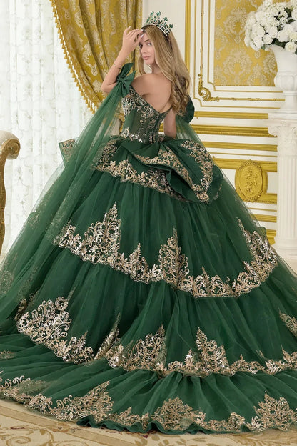 Woman in a green gown with gold embroidery in an ornate room.
