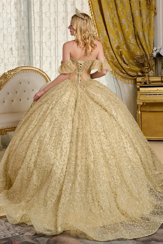 Woman in a gold gown standing in an elegant room with a piano and decorative curtains.