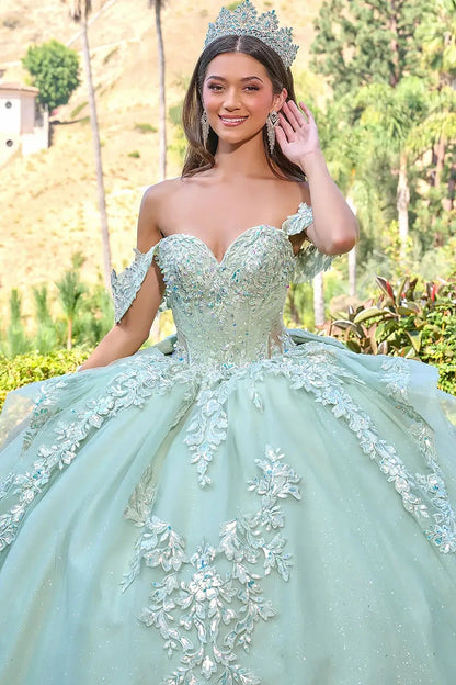 Woman in a sage green quinceañera dress with floral details and sweet heart neckline outdoors