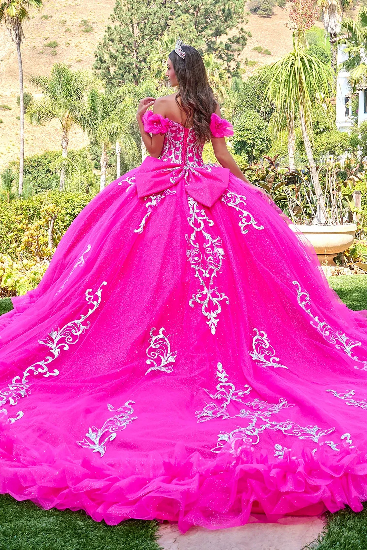 fuchsia pink  ball gown with white embroidery in an outdoor setting