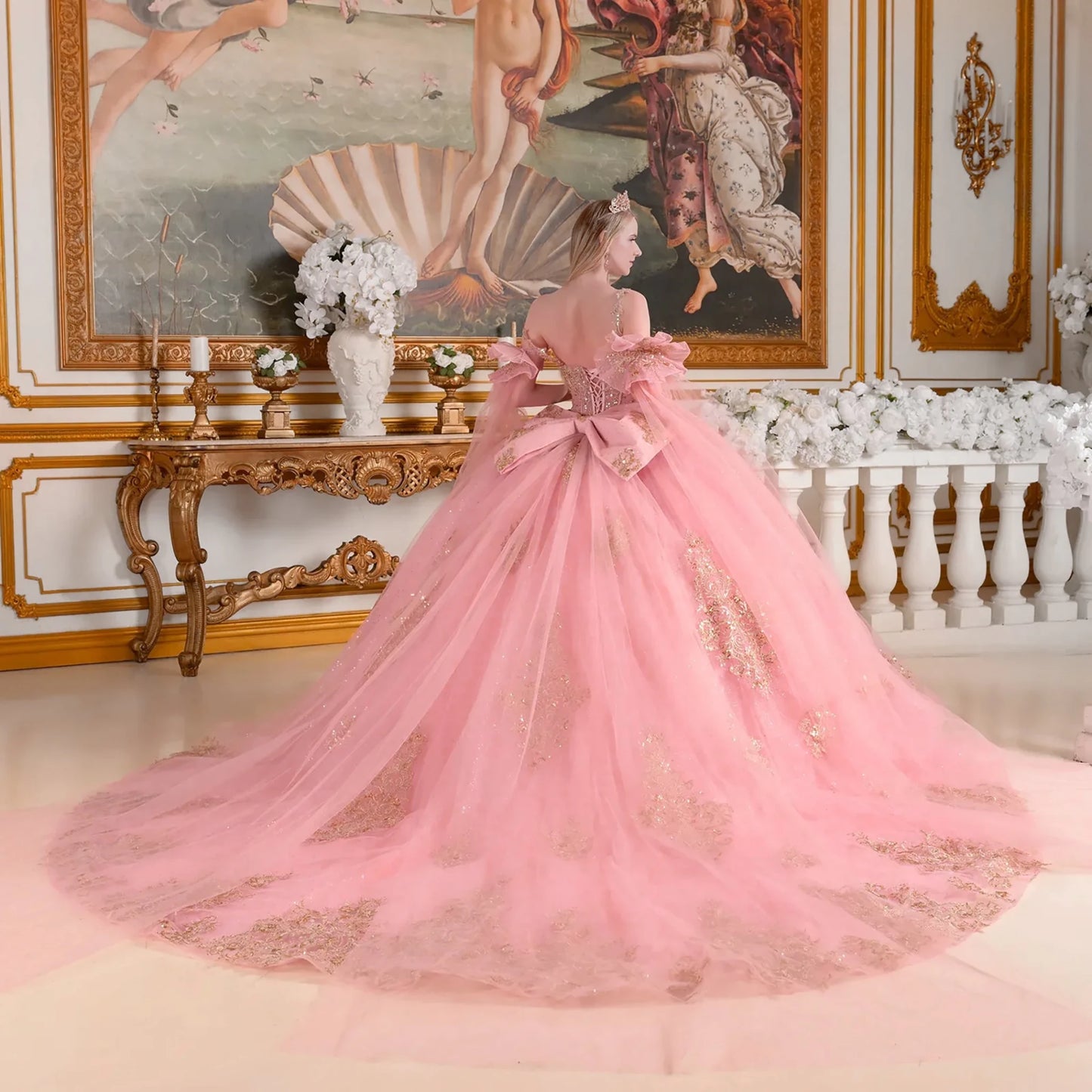 dusty rose gown with gold details in an ornate room with classical painting and decor.