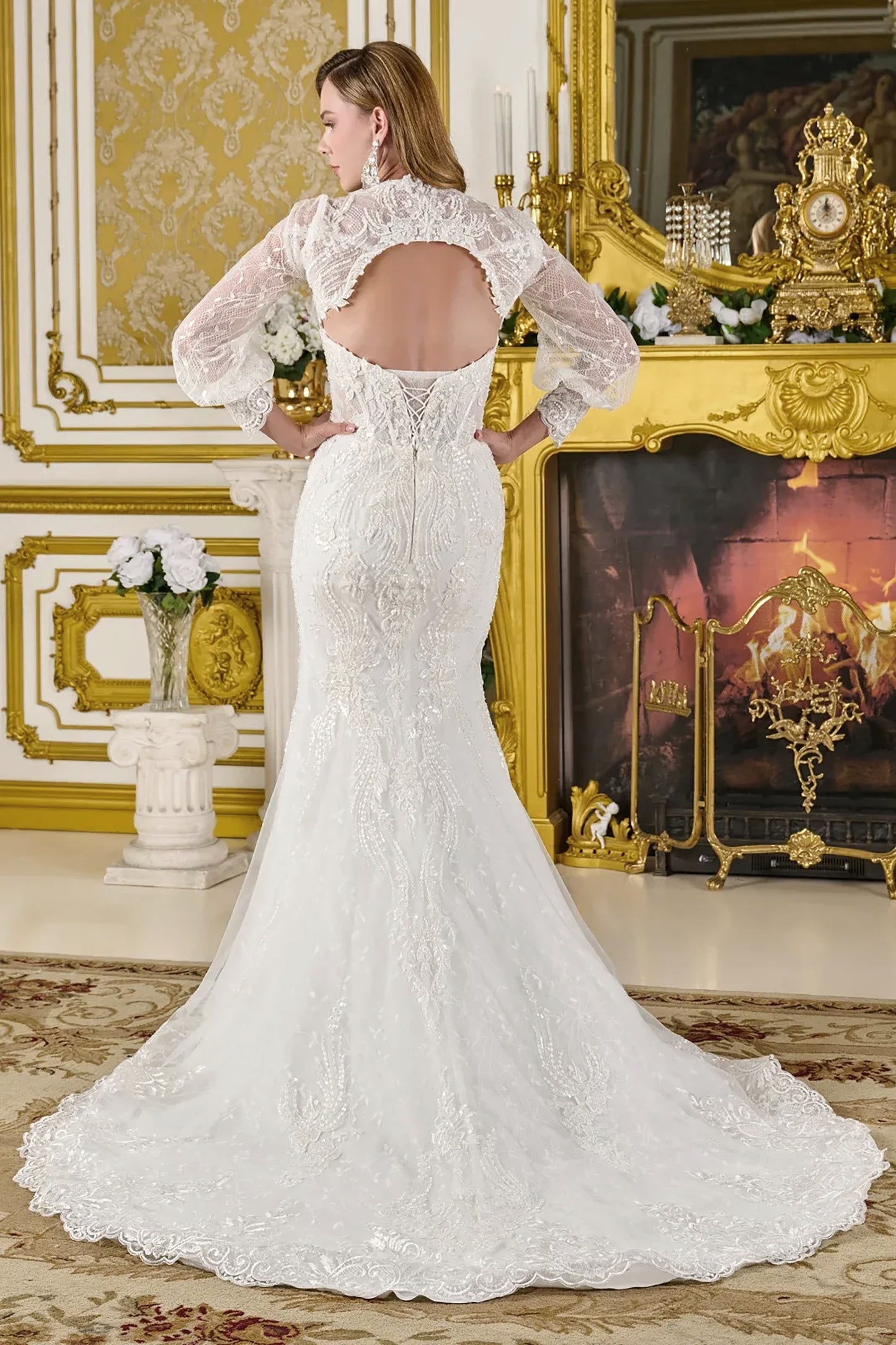 White lace wedding dress with long train in an ornate room.