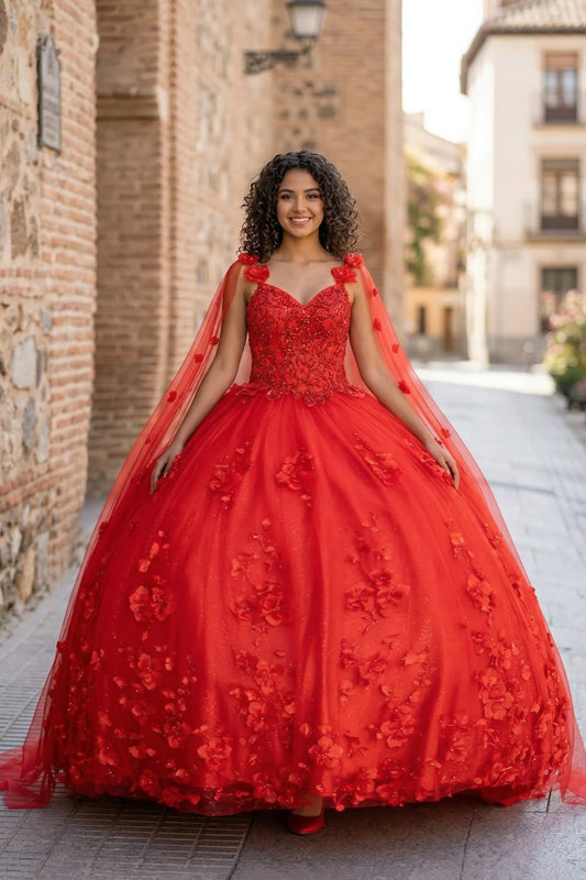 Girl in a red quinceanera ball gown with 3D floral details standing on a street.