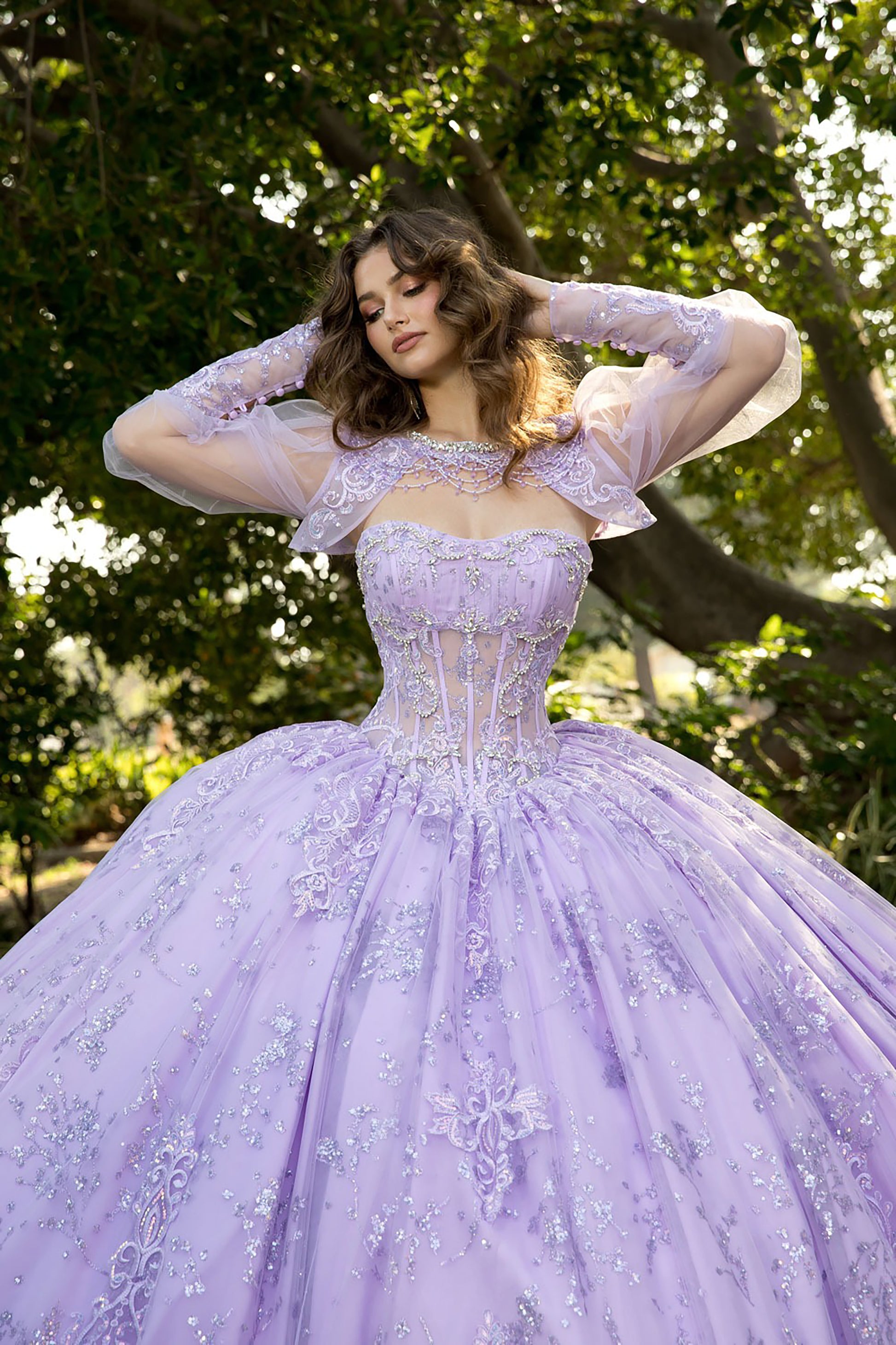 Woman wearing a lavender ball gown with floral details in a natural setting.