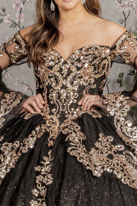 Black quince gown with gold embroidery and sheer sleeves against a floral background
