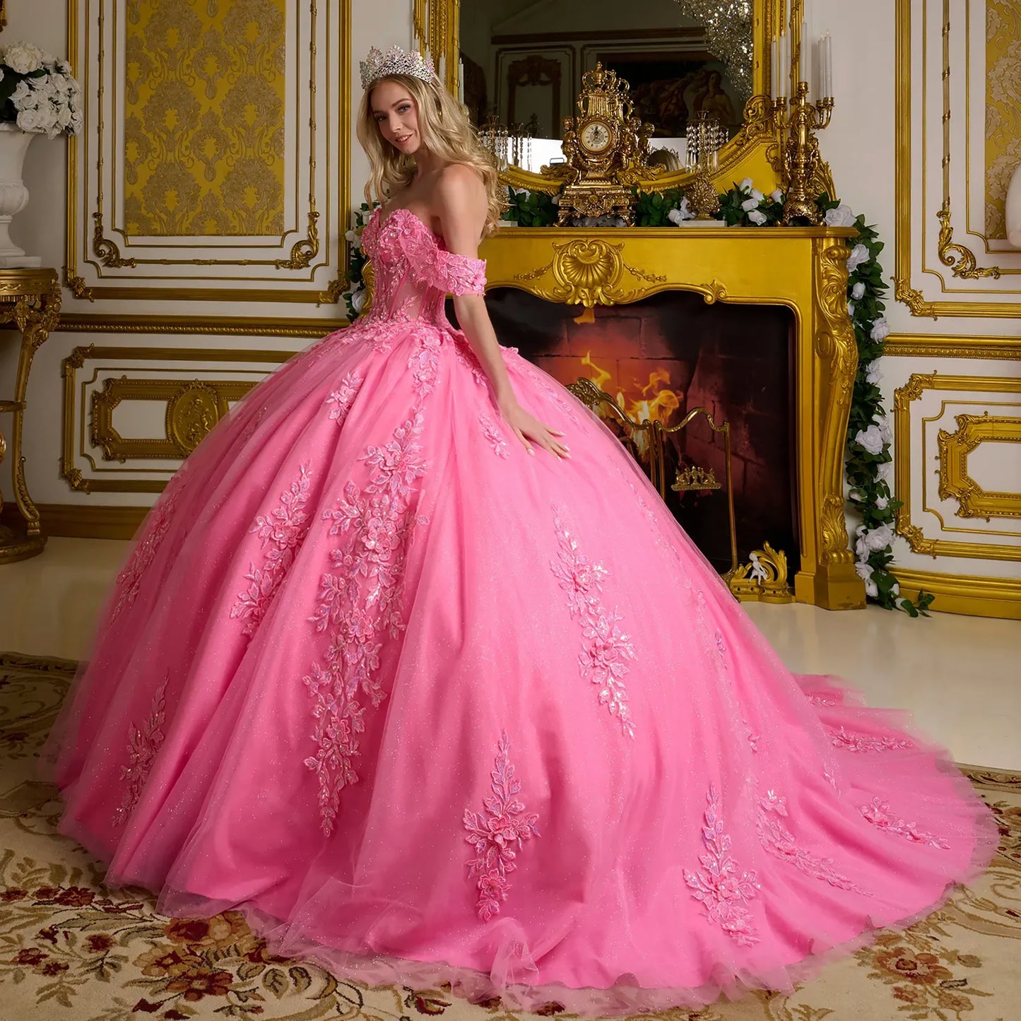 Woman in a pink gown with floral details in an ornate room.