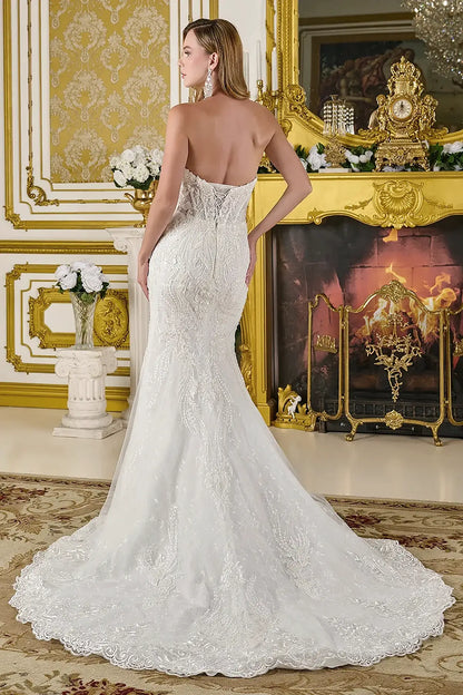 Woman in a white lace wedding dress standing in an opulent room with gold decor.