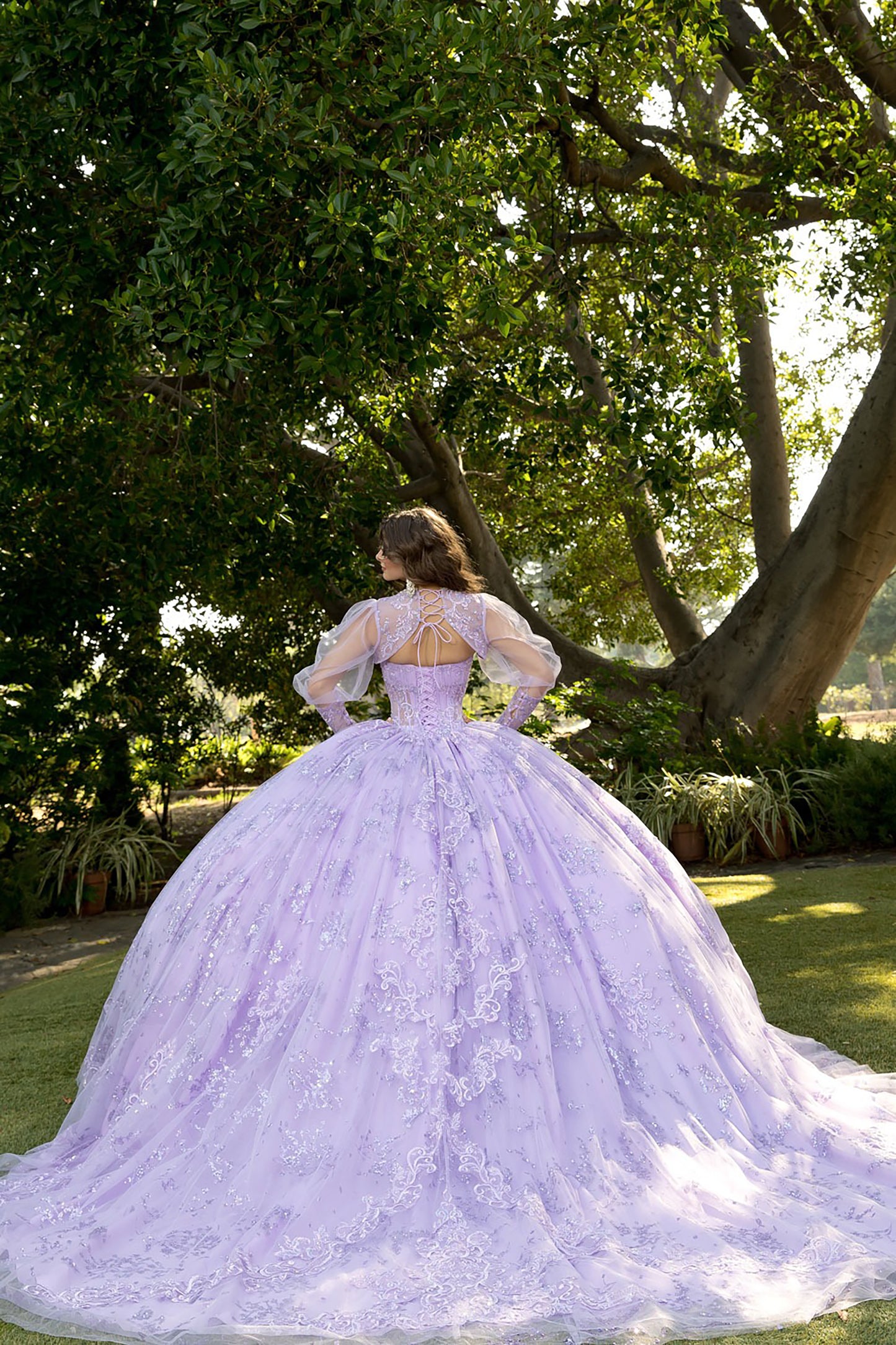 Woman in a lavender wedding dress standing outdoors with trees in the background