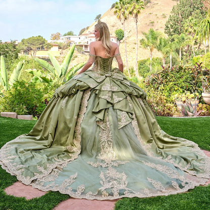 a girl wearing sage green quince dress and tiara showing her back in a green garden
