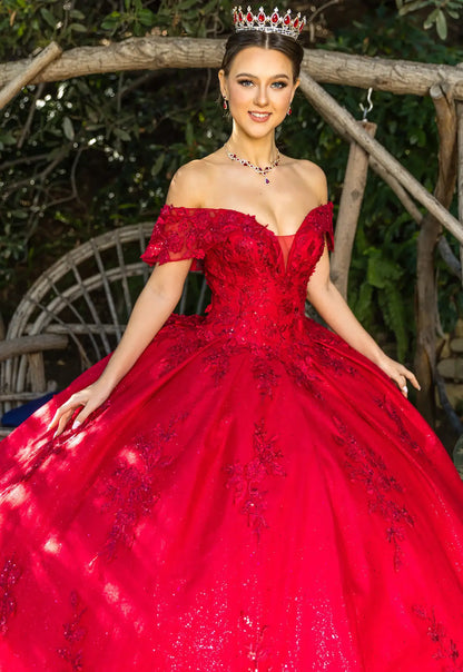 Woman in a red off-shoulder gown with intricate detailing outdoors.