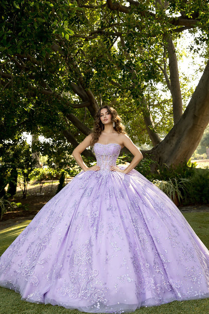 Woman in a lavender ball gown standing outdoors with trees in the background